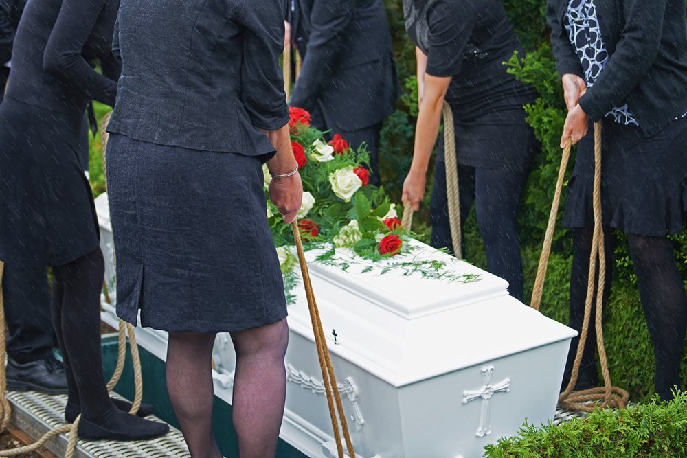 People Lowering A Casket